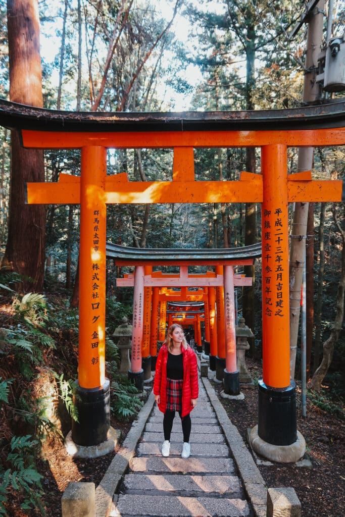 Hikers walking through a tunnel of vermilion torii gates on the Mount Inari trail, Kyoto