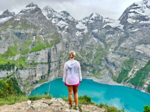 A person enjoying the panoramic viewpoint on the Oeschinensee Panorama Weg
