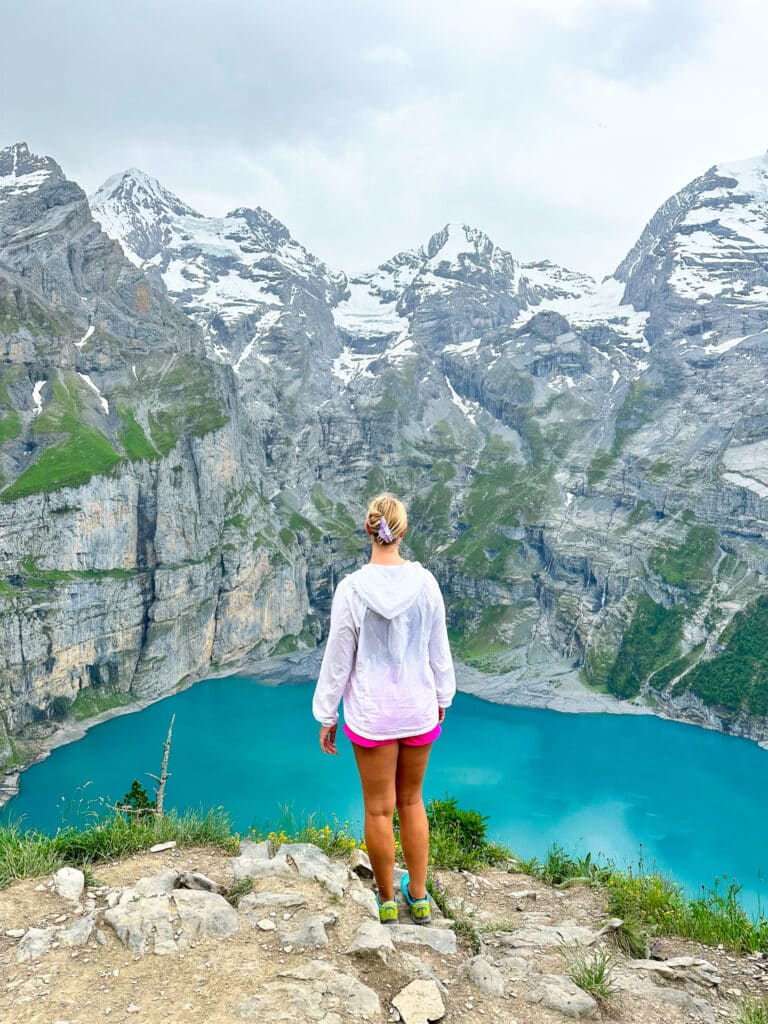 A person enjoying the panoramic viewpoint on the Oeschinensee Panorama Weg
