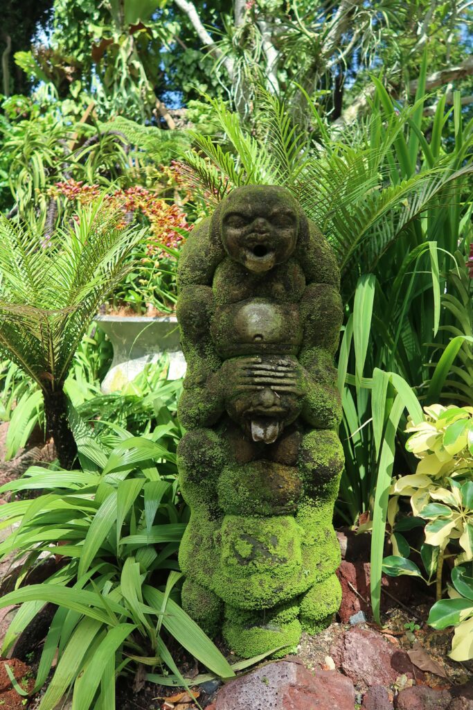 Mossy monkey statue in the National Orchid Garden, Singapore