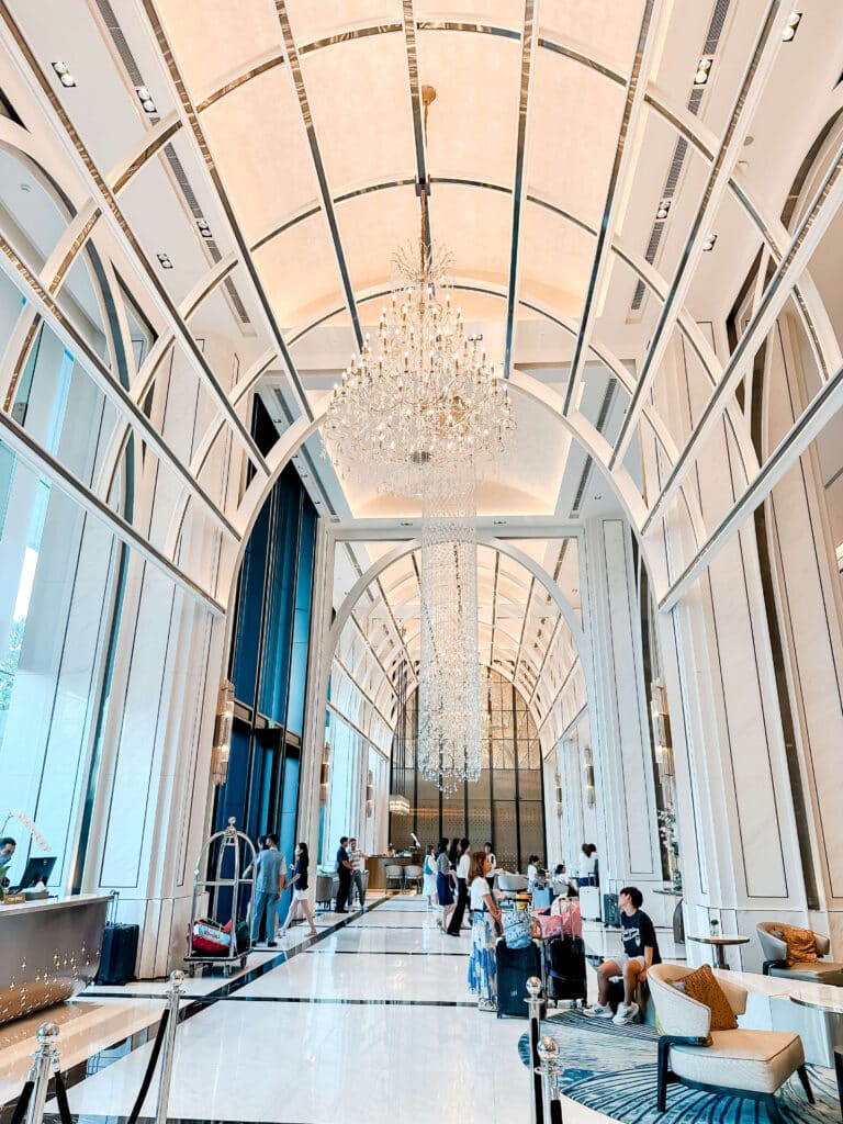 Grand arched lobby of Eastin Grand Hotel Phayathai with guests seated beneath chandeliers and floor-to-ceiling windows