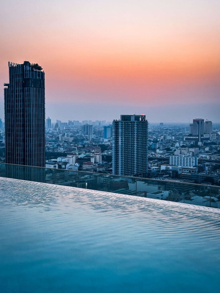 Infinity pool at Eastin Grand Hotel Phayathai with a view of the Bangkok skyline at dusk