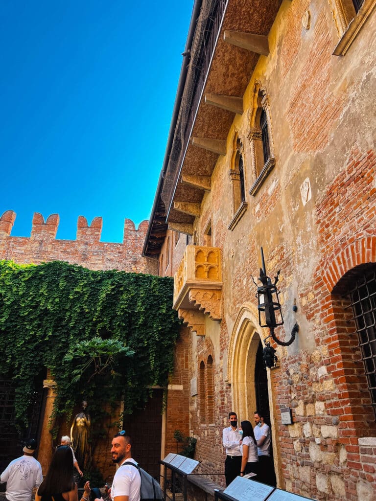 Close-up of Juliet’s balcony at Casa di Giulietta, framed by historic brick walls and vines.