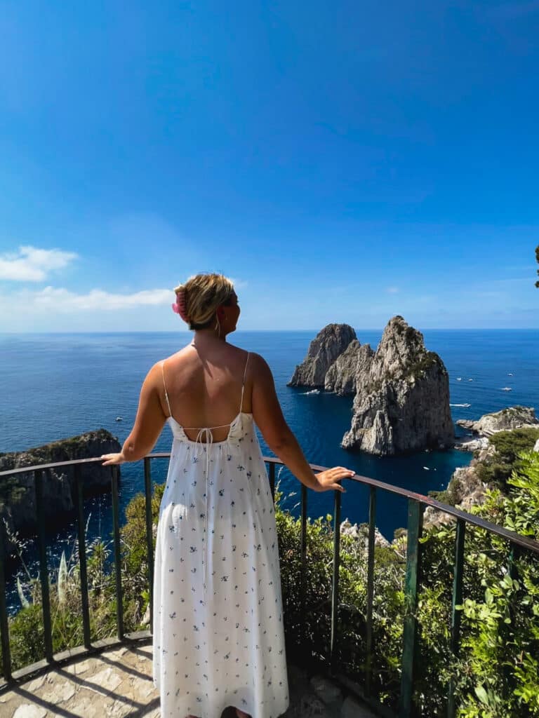 A hiker taking in the view of the La Fontelina Beach Club from an overlook along the Via del Pizzolungo / Via Tragara