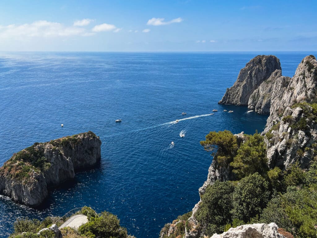 Classic view of the Faraglioni sea stacks rising from the blue water