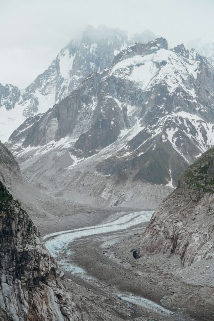 Panoramic view of the Mer de Glace cutting through steep valley walls in the French Alps.