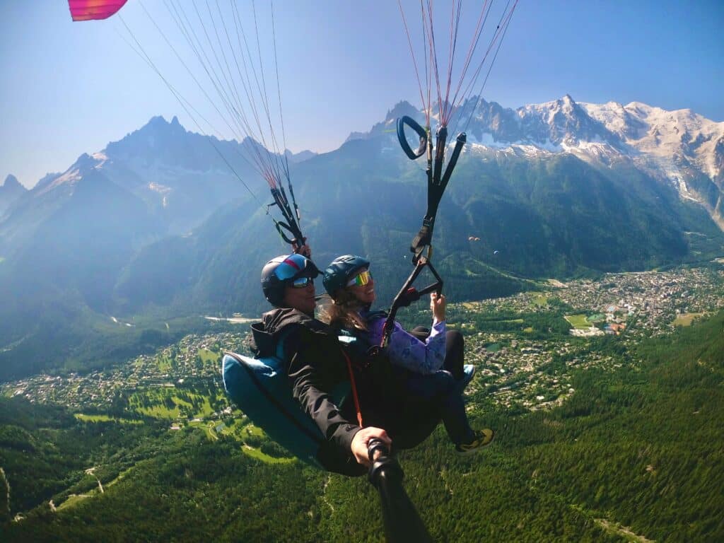 Tandem paraglider flying high above Chamonix with Mont Blanc in the background
