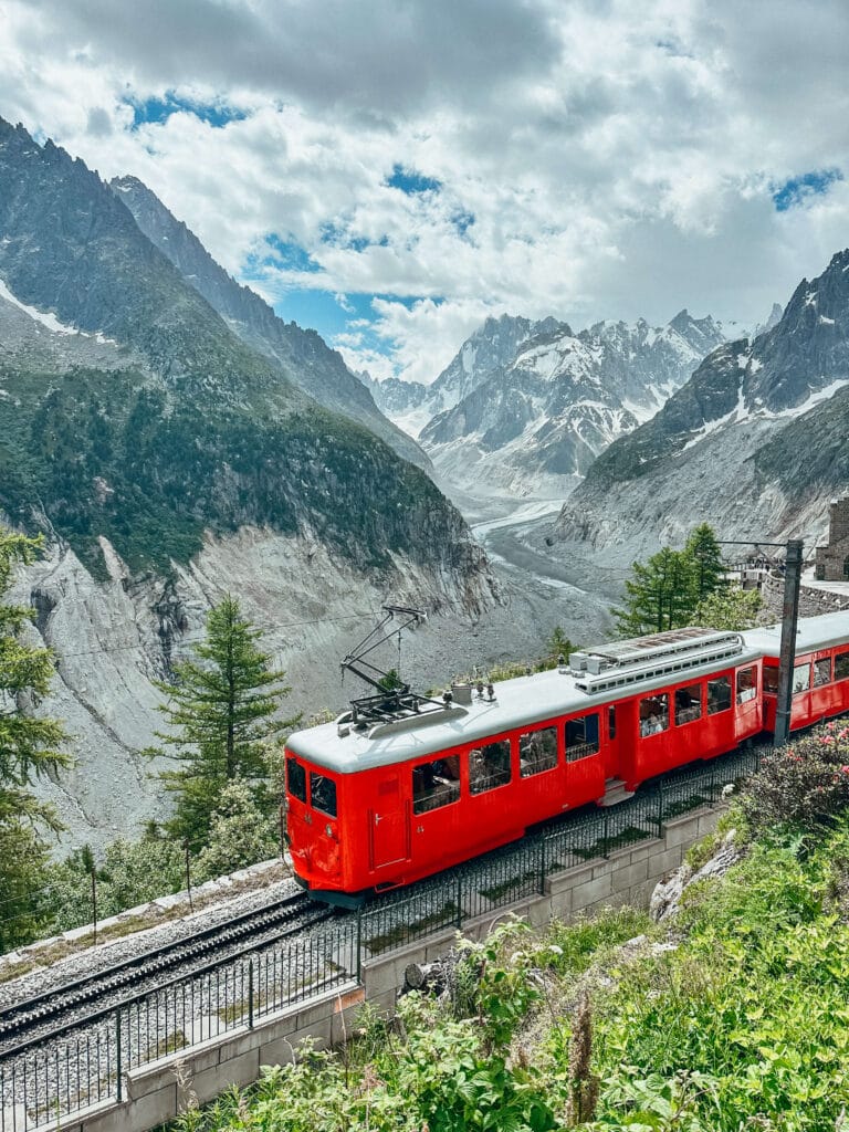 Bright red cogwheel train climbing through the alpine landscape above Mer de Glace.