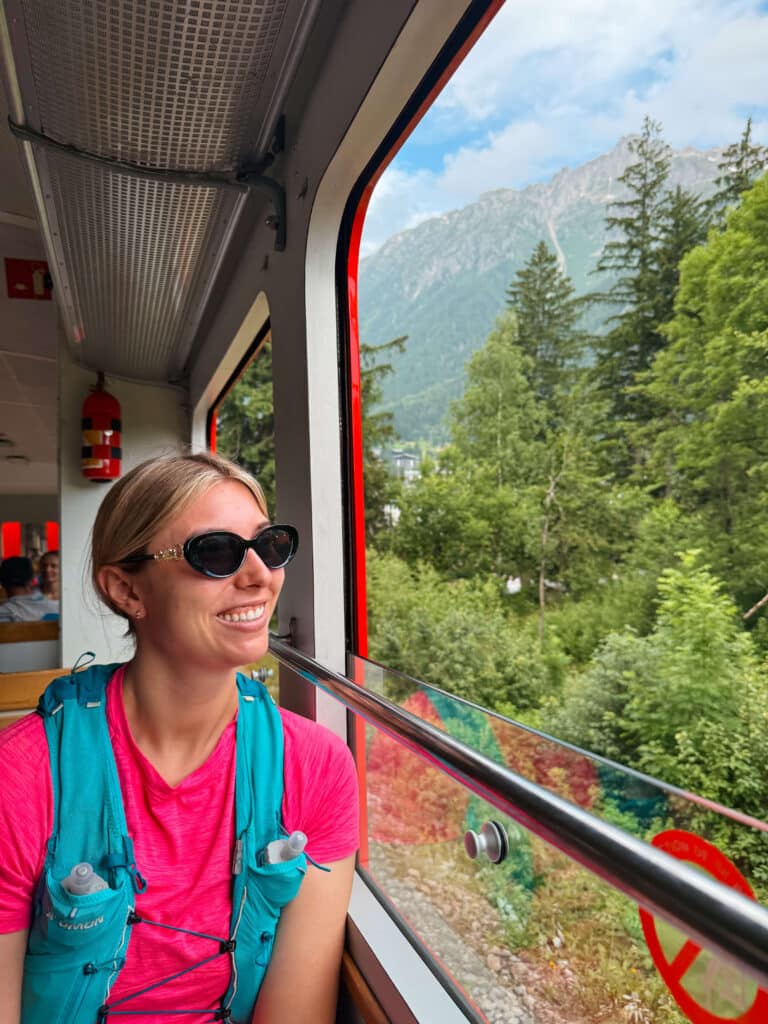Traveler in sunglasses looking out the train window as it climbs toward Montenvers.