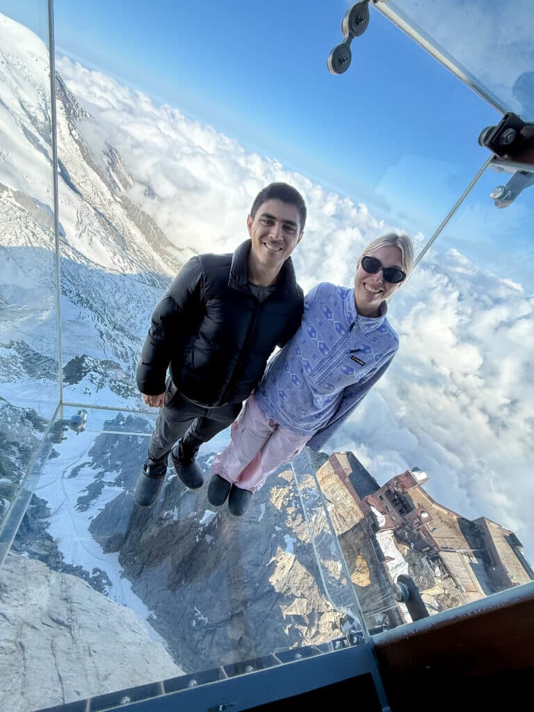Two people standing in a glass box at the Step Into the Void experience