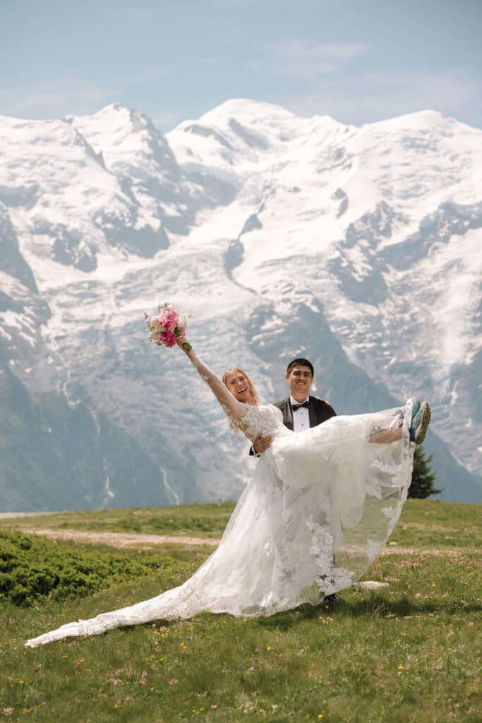 Groom carrying bride across the meadows at Planpraz. Photo credit: Mathilde Rietsch.