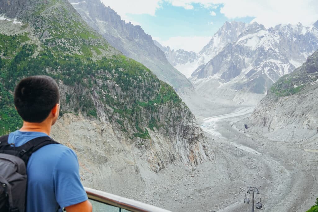 A tourist looking out over the scree covered Mer de Glace Glacier