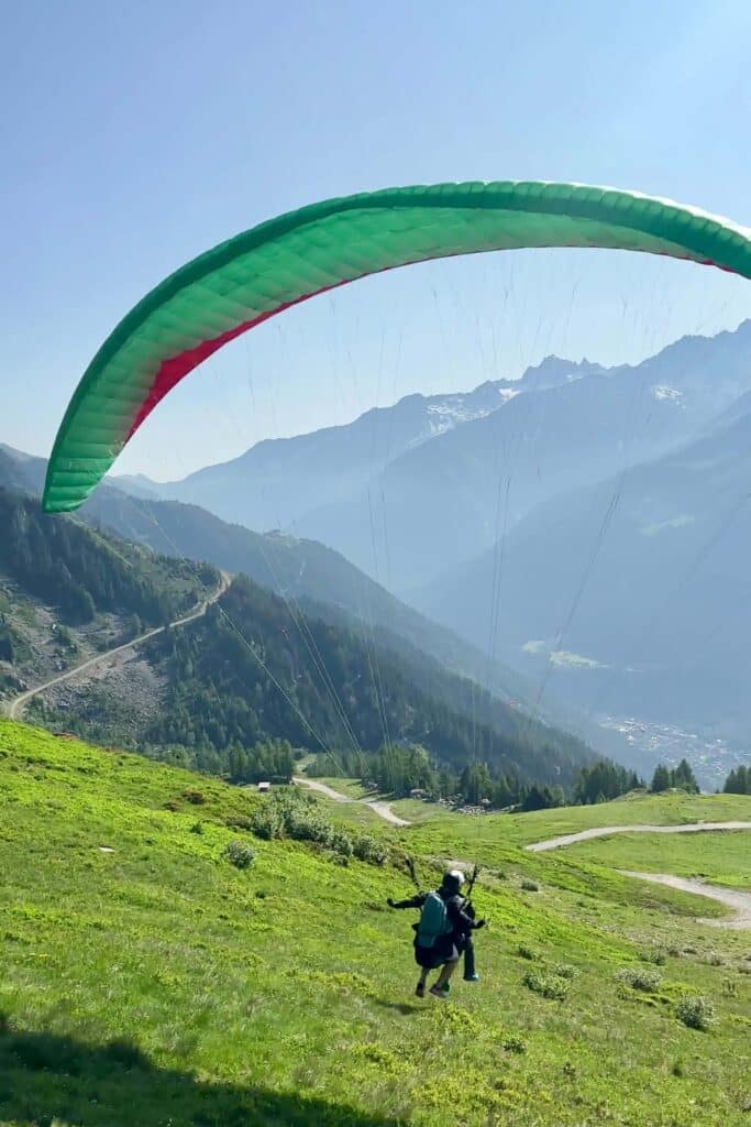 Paraglider catching lift just after takeoff with the Chamonix mountains in the background