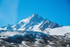 Close-up of the cracked and crevassed surface of the Albert 1er Glacier beneath the towering summit of Aiguille du Chardonnet.