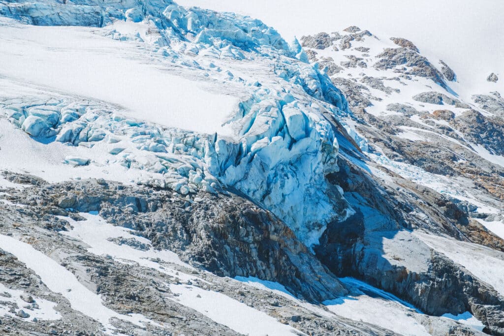 Close-up view of jagged glacier ice, with streaks of blue cutting through compacted snow.