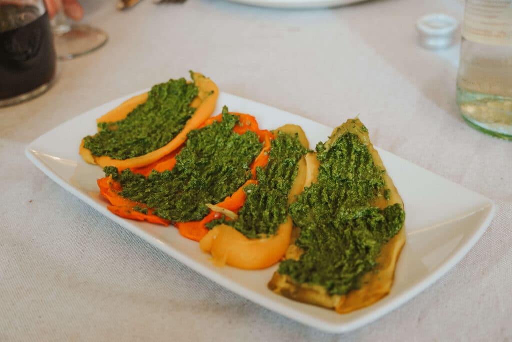 Colorful roasted peppers topped with a vibrant green Piedmontese sauce