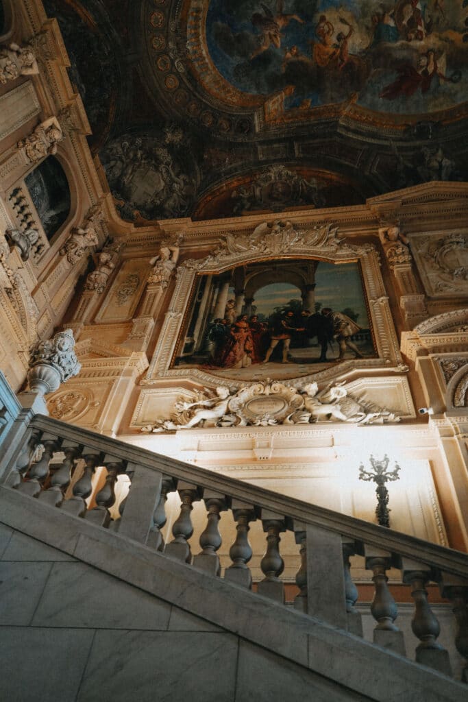 Marble staircase in the Royal Palace of Turin, featuring a fresco above the landing and balustrade.