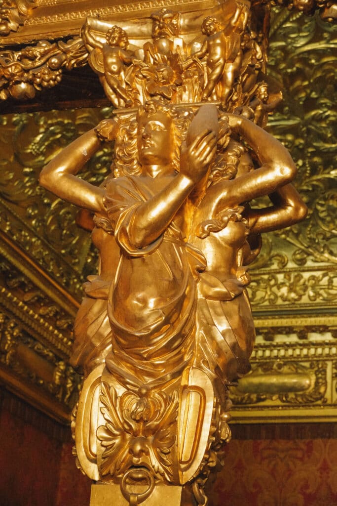 Close-up of a gold cherub detail carved into the ceiling of the Royal Palace of Turin.