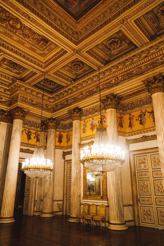 Lavish gold-trimmed ballroom with coffered ceiling and crystal chandeliers in the Royal Palace of Turin.