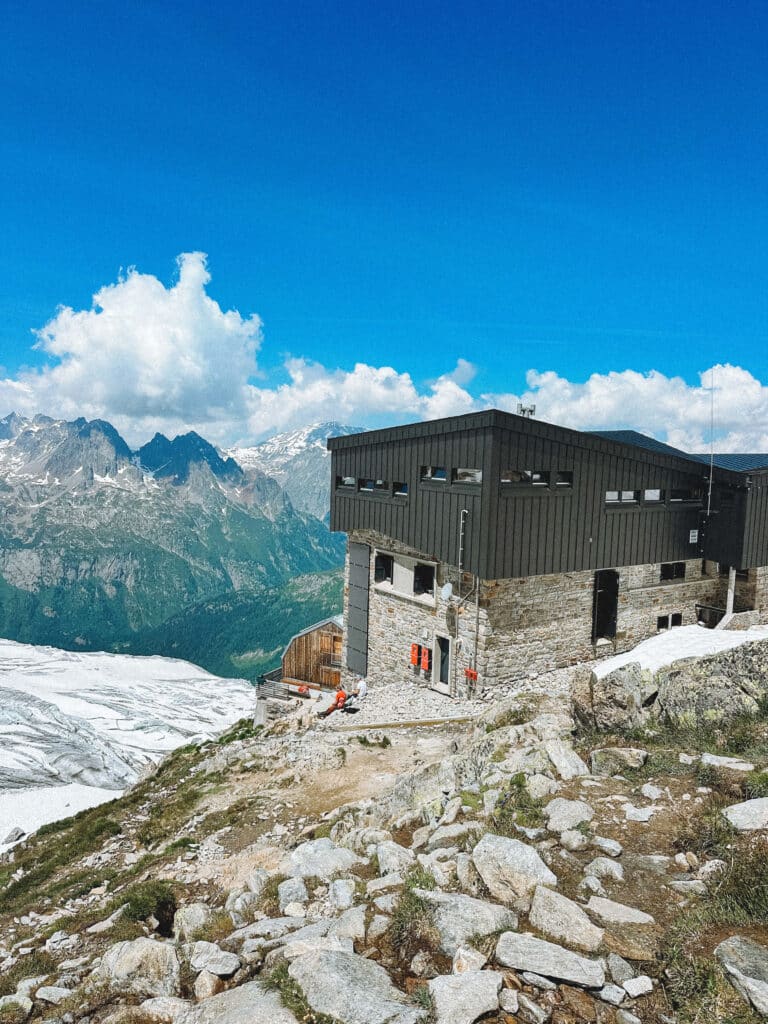 Refuge Albert 1er perched high above the glacier, with panoramic views in the distance.