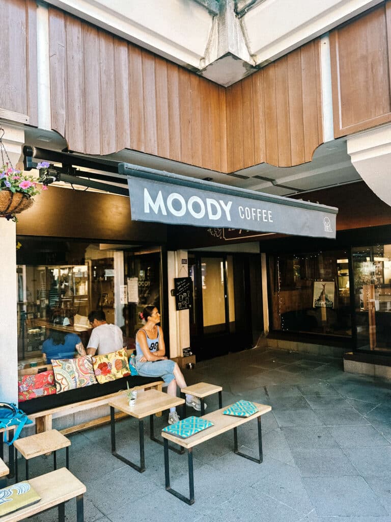 Exterior of Moody’s Coffee Roastery in Chamonix with small tables and benches out front.