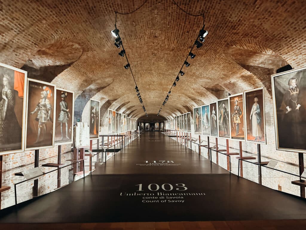 Exhibit hallway inside the Venaria Reale, lined with paintings of the Savoy family and soft overhead lighting