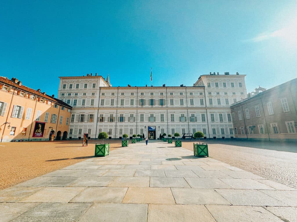 Exterior courtyard of the Royal Palace of Turin under a bright blue sky