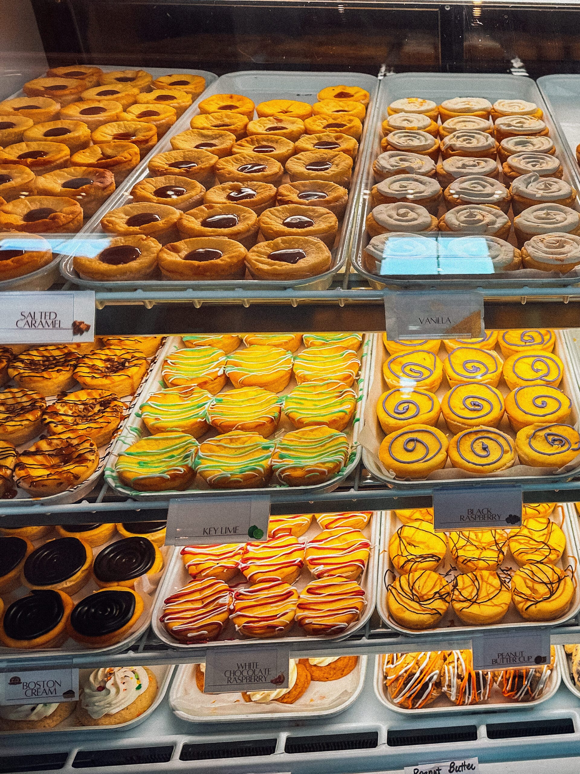 Shelves stocked with bright cheese tarts inside a farm shop.