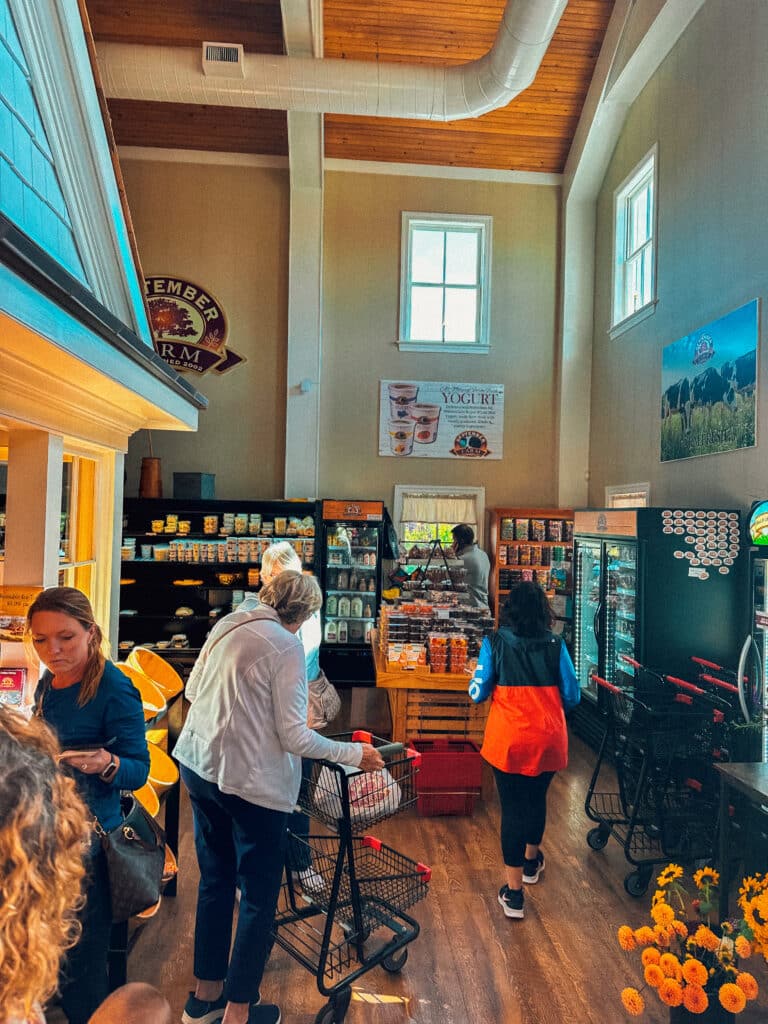 Interior of September Farm Cheese shop with tall ceilings, and an assortment of display cases holding treats
