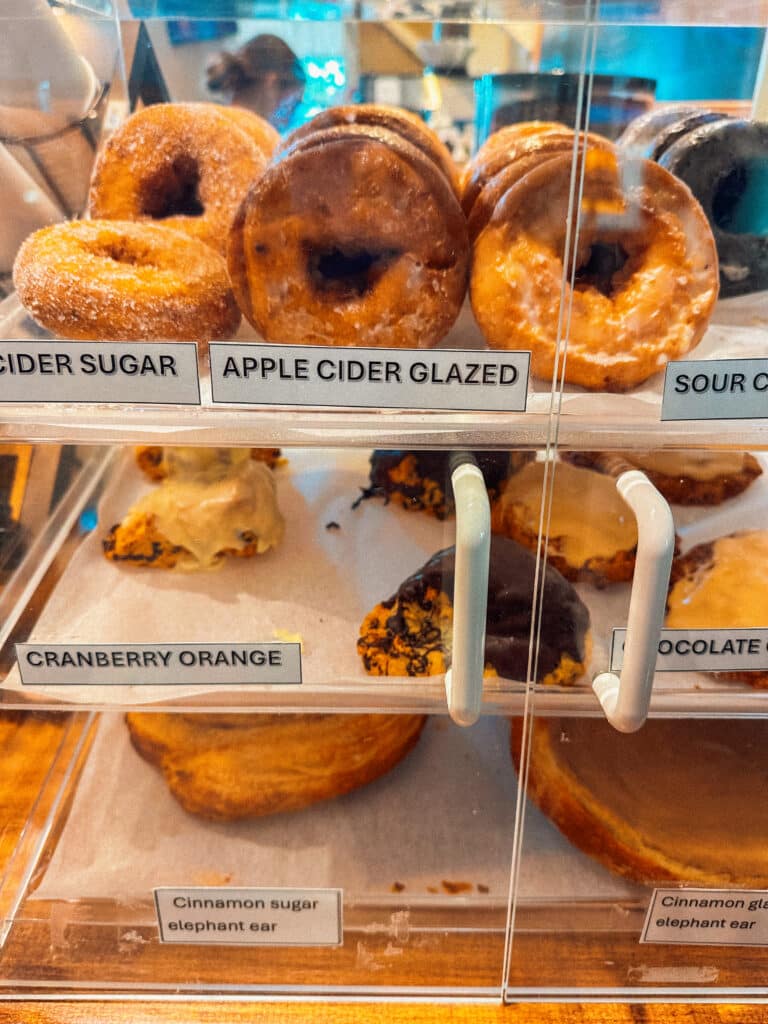 Autumnal donuts stacked inside a clear display case