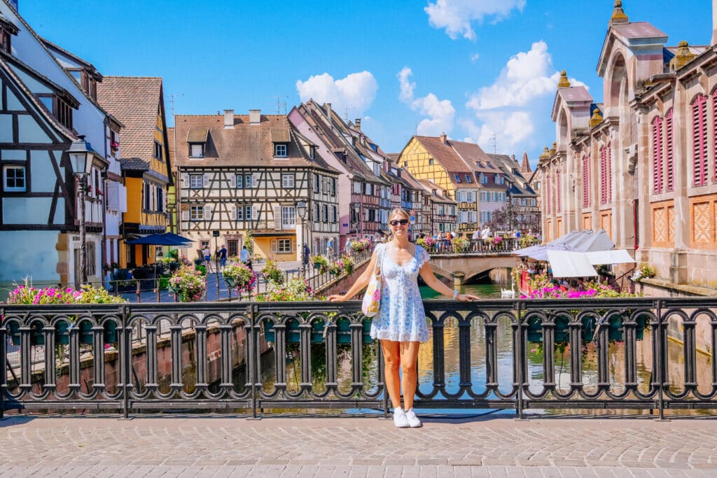 Woman in white dress facing away from the camera on a bridge in Petite Venise, Colmar