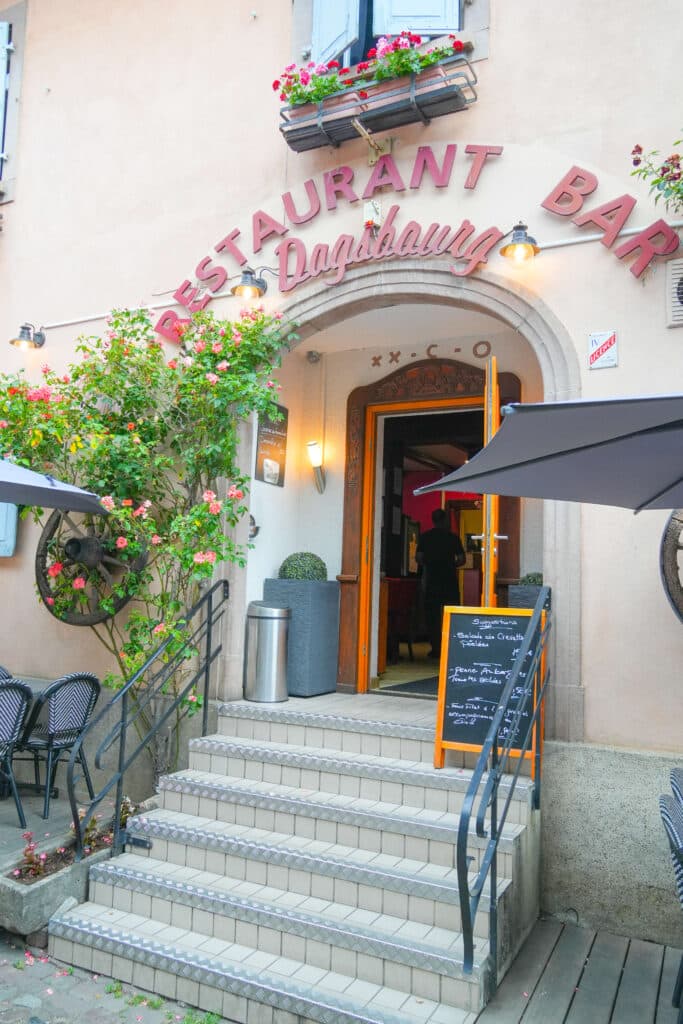Entrance to Restaurant Dagsbourgh with white stairs and pink flower boxes.