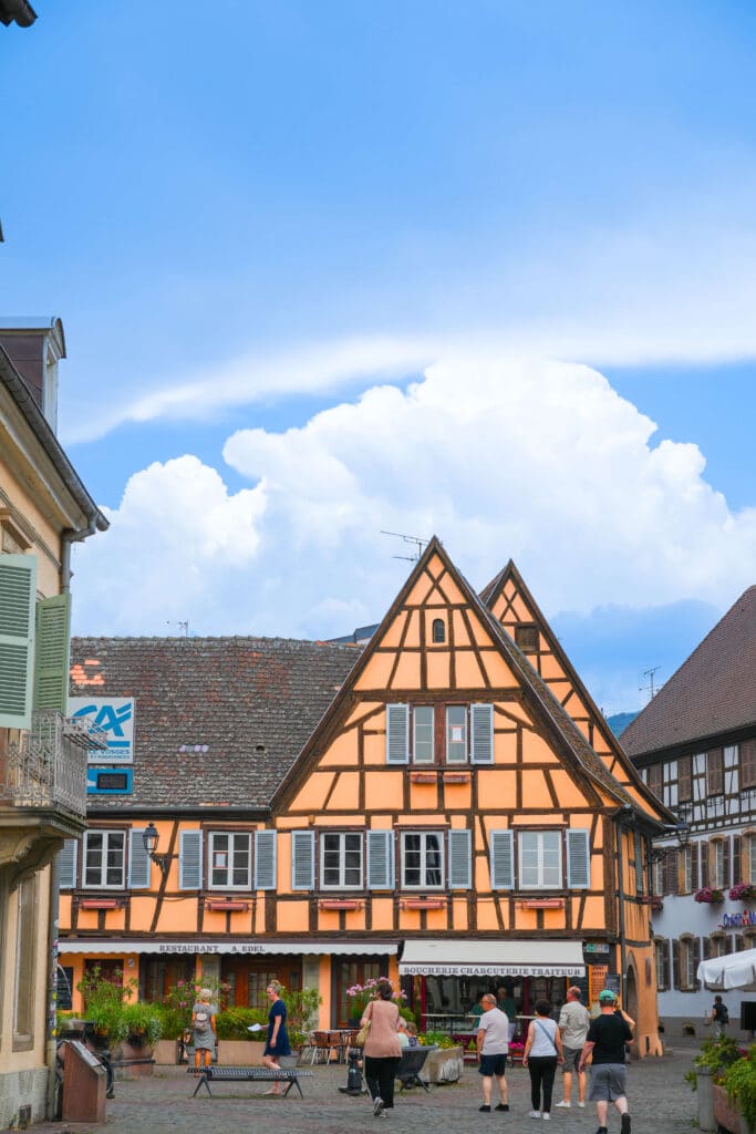 Half-timbered building with steep roof in Eguisheim’s town square.
