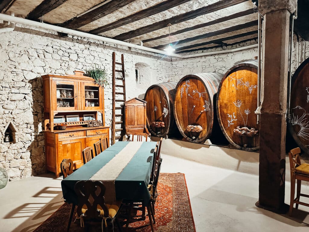 Wooden wine barrels inside a cozy Alsace wine cellar tasting room at Sipp Mack