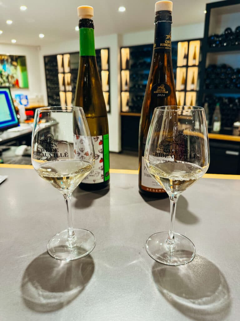 Display of elegant wine bottles at Cave de Ribeauvillé tasting counter