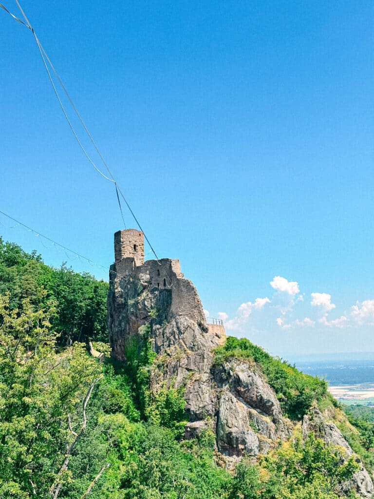 Ruins of Girsberg Castle perched dramatically on a rocky outcrop above the forest