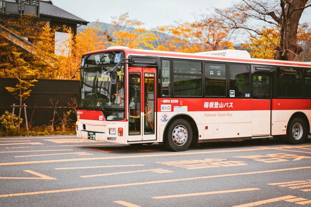 A Hakone Tozan bus captured against vibrant autumn colors in the street.