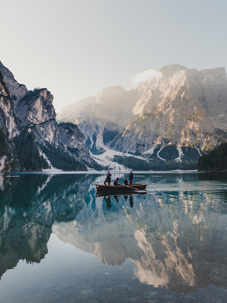 A picturesque boat ride on Lake Braies with stunning mountain reflections, capturing serene natural beauty.
