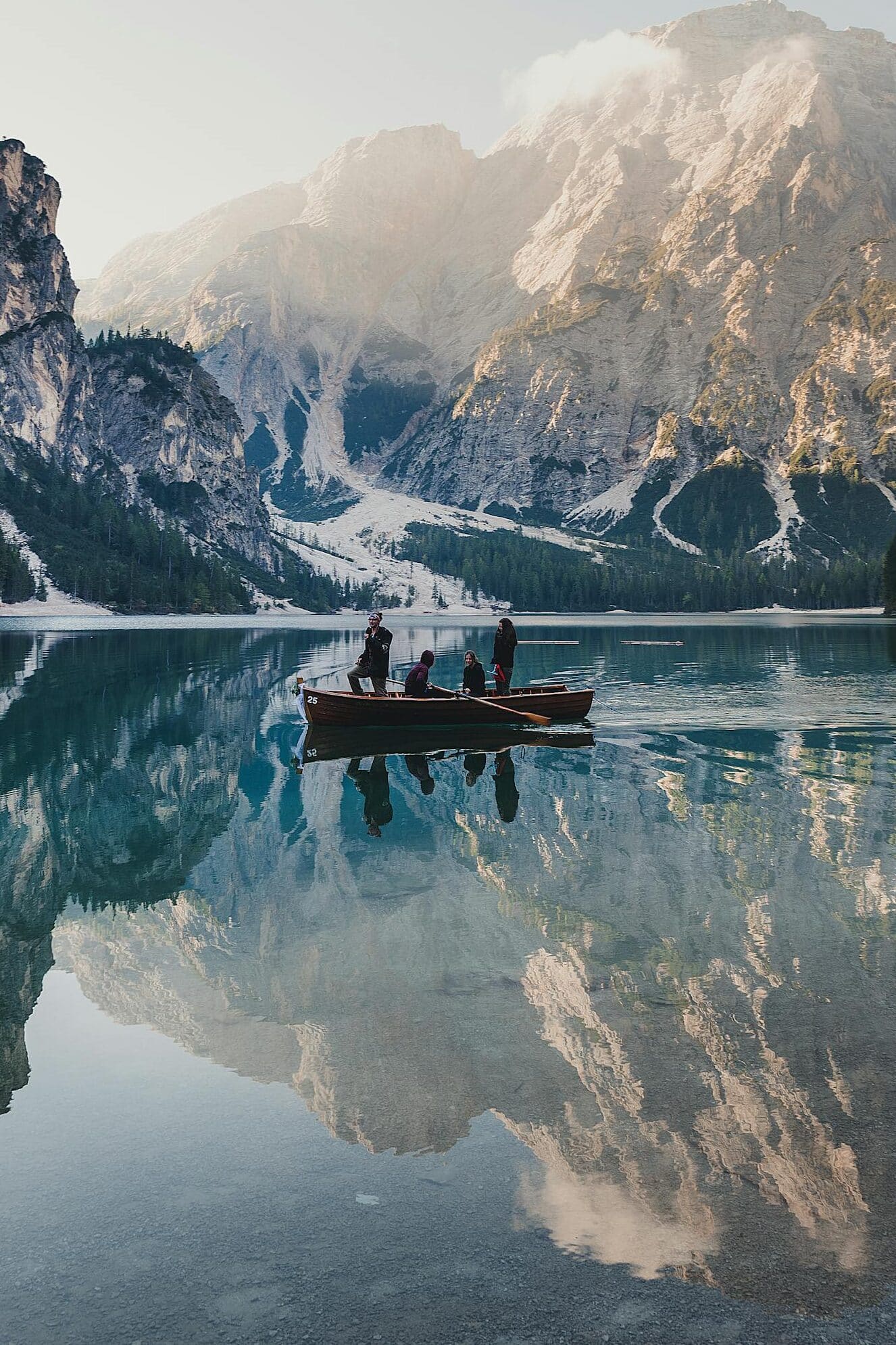 A picturesque boat ride on Lake Braies with stunning mountain reflections, capturing serene natural beauty.