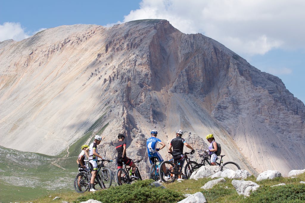 Group of cyclists mountain biking in the scenic Dolomites, Italy on a sunny day.