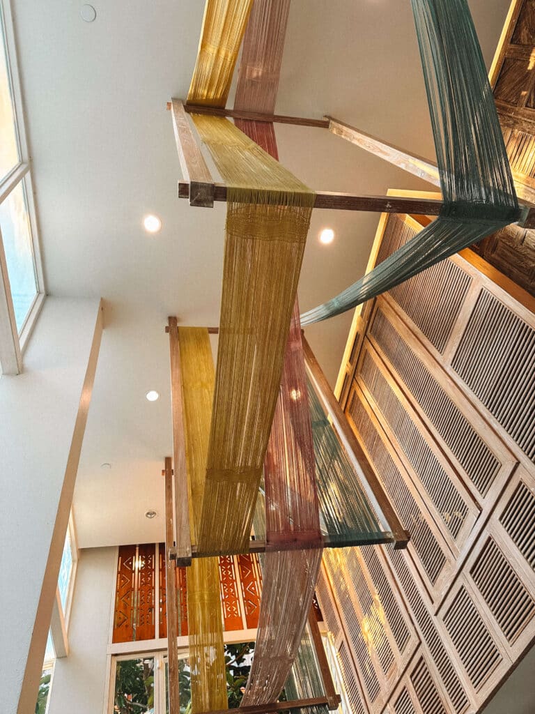 Colorful hanging textile art installation in the lobby of Pastell Oldtown Chiang Mai.