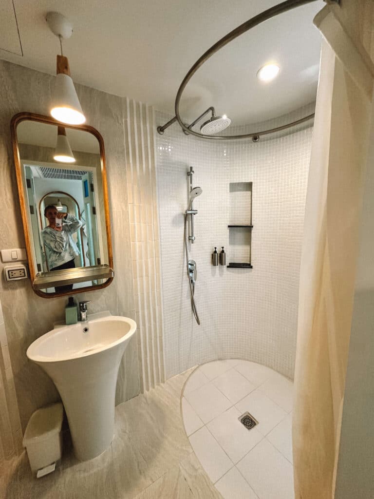 Compact bathroom at Pastell Oldtown Chiang Mai with modern sink, mirror, and tile details