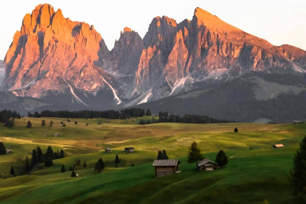 Scenic sunrise view of Alpe di Siusi in Trentino-South Tyrol with majestic Dolomites and lush grasslands.
