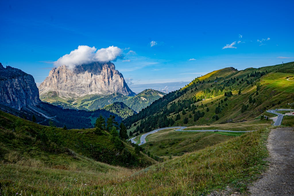 Stunning landscape of Dolomites with clear blue sky and winding roads in Trentino-Alto Adige.