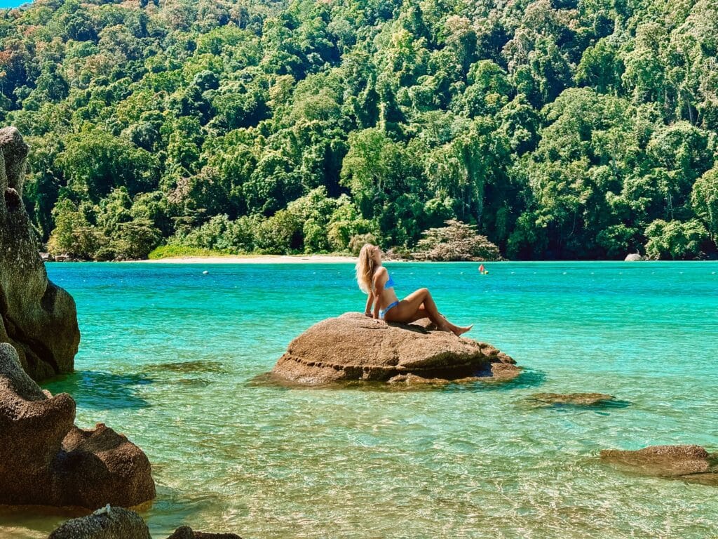 A traveler lounging on a rock in the sun at the Surin Islands near Khao lak