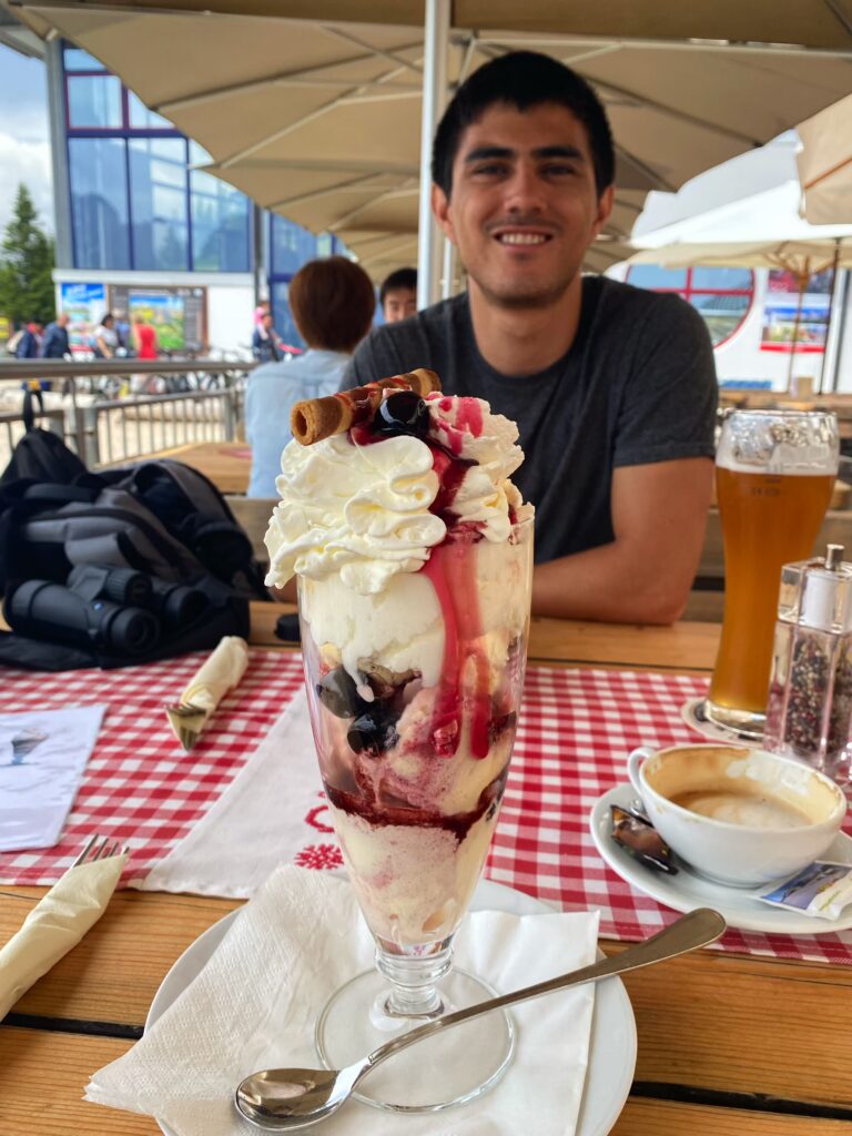 A traveler grinning before an ice cream monstronsity