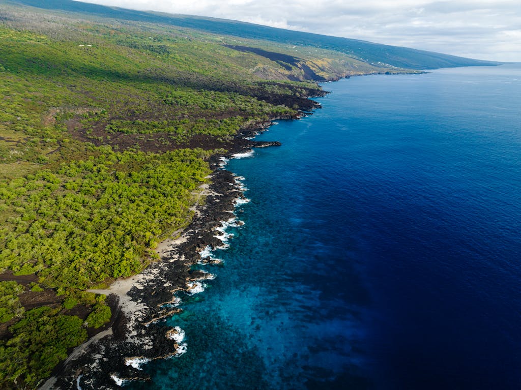 Stunning aerial view of the lush coastline and blue waters of Honaunau-Napoopoo, Hawaii.