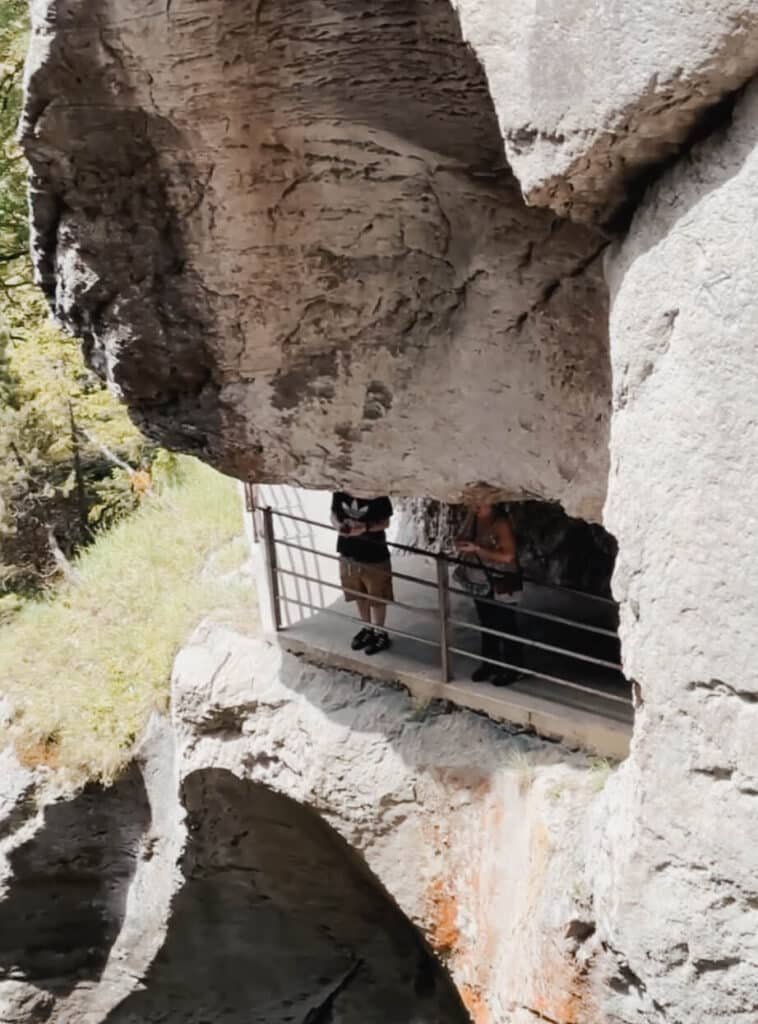 Exterior viewpoint at Trümmelbach Falls showing cliffside walkway carved into the rock