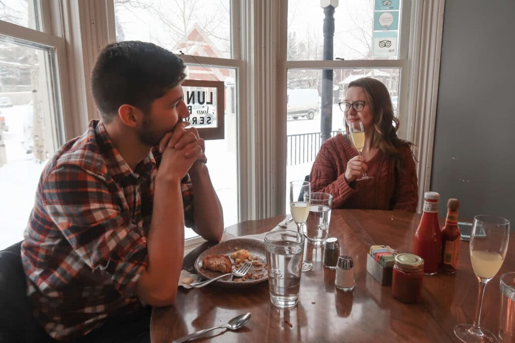 Friends warming up with brunch and coffee inside a cozy café in Breckenridge.