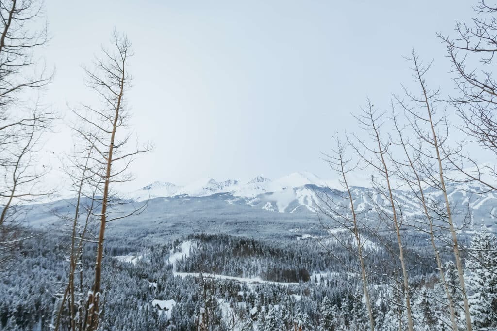 Snowy mountain views overlooking the town of Breckenridge under pale snowy skies.